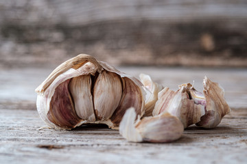 raw garlic on grey old wooden Board close up