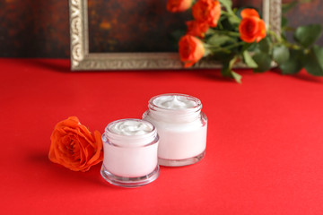 Body cream with rose flower on color table
