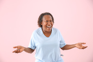 Portrait of carefree African-American woman on color background