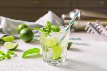 Glass of fresh mojito on white table