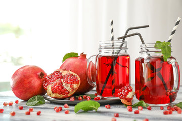 Mason jars of fresh pomegranate juice on table