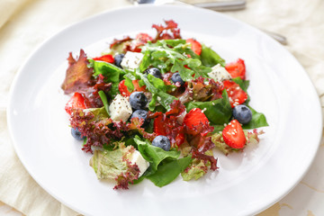 Plate with fresh tasty salad on table, closeup