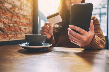 A woman using credit card for purchasing and shopping online on mobile phone