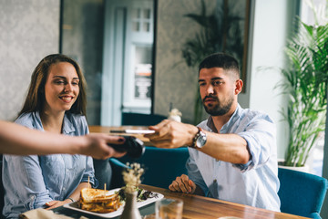 man paying the bill in restaurant contactless with his cellphone