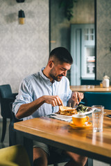 man having dinner or breakfast in restaurant