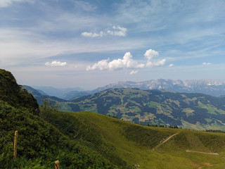 Obraz premium Beautiful alpine landscape with green meadows, alpine cottages and mountain peaks, Tyrol Alps, Austria