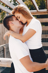 Cute couple in a park. Lady in a white t-shirt.