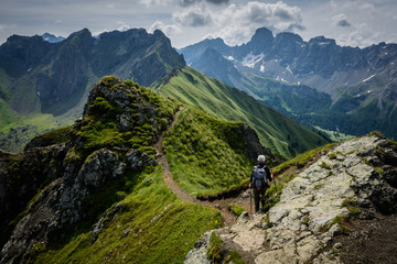Fototapeta na wymiar Un escursionista solitario percorre un sentiero in cresta in alta quota sulle Dolomiti