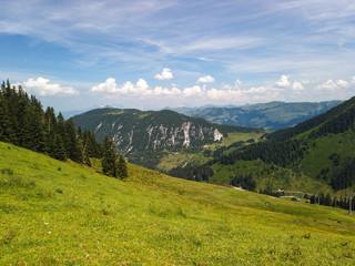 Obraz premium Beautiful alpine landscape with green meadows, alpine cottages and mountain peaks, Tyrol Alps, Austria