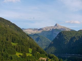 Fototapeta premium Beautiful alpine landscape with green meadows, alpine cottages and mountain peaks, Tyrol Alps, Austria