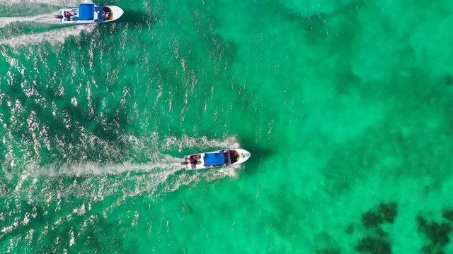 Aerial: A Tour Boat Passes Another Tour Boat Driving Across a Tropical Ocean - Tulum, Mexico