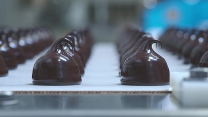 Chocolate candy bars production - food industry process. A lot of chocolates on the production line.