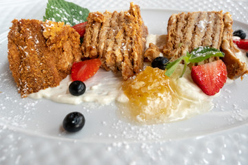 Dessert honey cake with strawberries on a plate