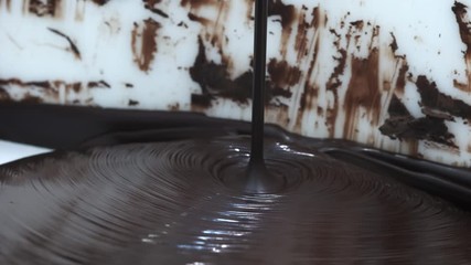 Chocolate. Pouring melted liquid premium dark chocolate. Close up of molten liquid hot chocolate swirl. Confectionery. Confectioner prepares dessert, icing.