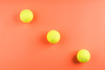 Three tennis balls on orange. Concept