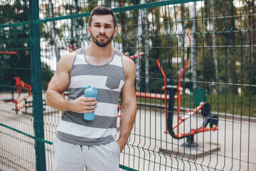 Handsome man in a park. Sportsman in a sportswear. Guy training