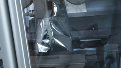 Packs sweets on a production line. Modern Thermo-packaging. Parcel trailer unloading to conveyor belt system