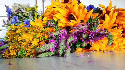 Close-up of a bouquet of wildflowers lies on a table, summer concept, rudbeckia, cornflower, chamaenerion, helichrysum arenarium, selective focus
