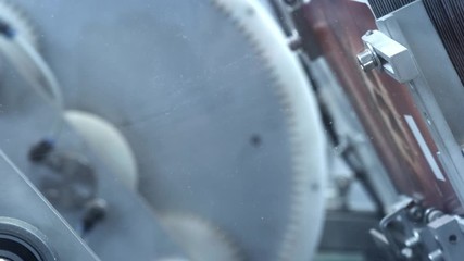 Labeling machine at water production line. Water products labeling at dairy factory. Close up packing water bottles. Label water bottles. Bottle label at dairy plant