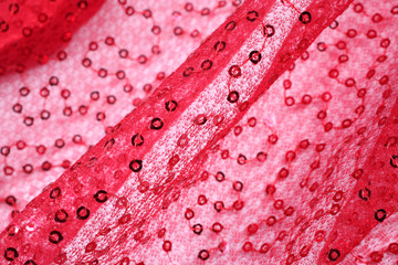 Close-up texture of red fabric with small rings on filament