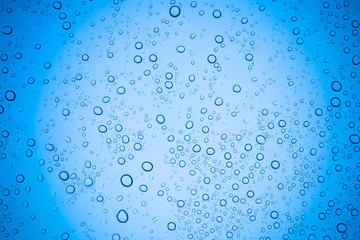 Rain droplets on blue glass background, Water drops on glass.