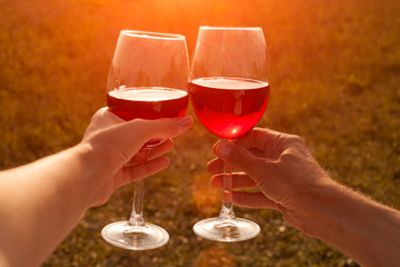 Man and woman clink glasses with red wine