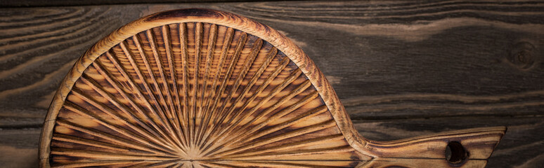 panoramic shot of wooden cutting board on brown table