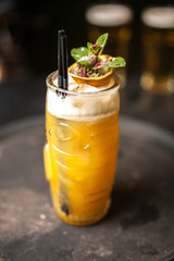 Orange cocktail on dark bar