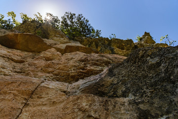 a view of the brown sloping slope with grass on top on a clear sunny day, the sun's rays make their way through the grass.