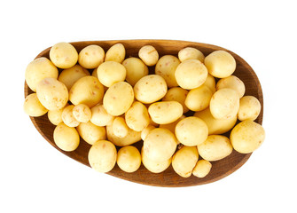 young potatoes on wooden plate isolated on white