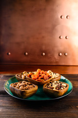 Various types of nuts - walnuts, pecans, peanuts, hazelnuts, almonds, cashews, in bowls, on marble table