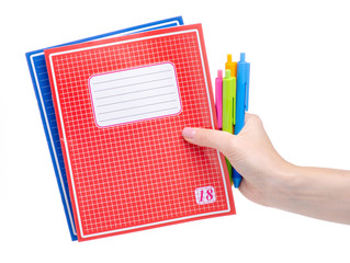 School exercise book notebook with pen in hand education on white background isolation