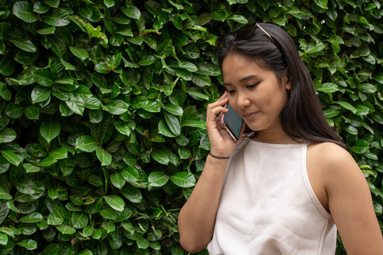 giovane ragazza con sfondo verde mentre parla al telefono
