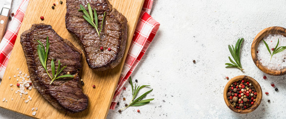 Fototapeta Grilled beef steak on wooden cutting board. obraz