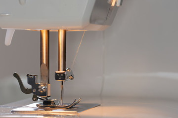 Betriebsbereite Nähmaschine mit Licht im Detail mit eingelegten Fäden und Spule