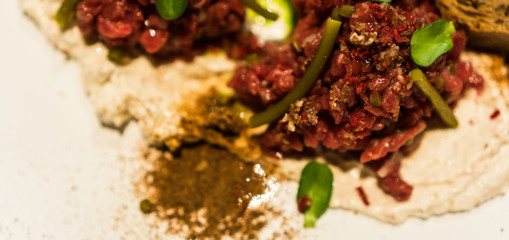 Tasty tartare made from toasted bread, spices, asparagus and chopped onions. Healthy lunch meal made of raw meat. Classical French cuisine. blurred focus
