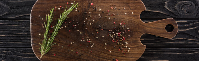 Fototapeta na wymiar panoramic shot of wooden chopping board with spices and rosemary