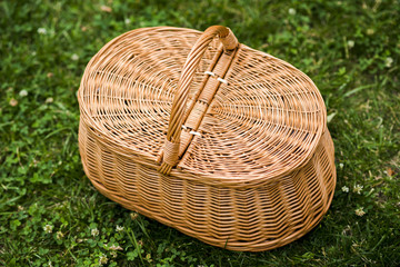 Fototapeta premium Wicker picnic basket on grass top view