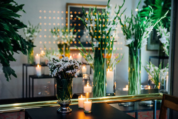 Glass vase with white flowers and a background painting. Interior design.