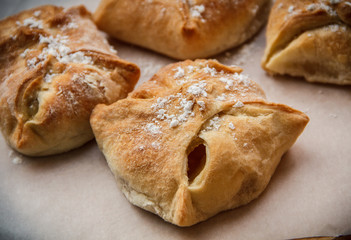 Apple buns. Fresh cakes. Fruit pies lie on a wooden table.