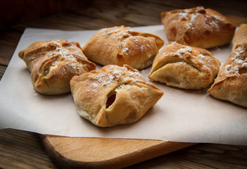 Apple buns. Fresh cakes. Fruit pies lie on a wooden table.