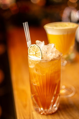 Close-up orange cocktail on the bar, blurred background.