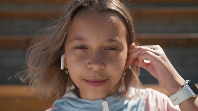 Portrait of kid outdoor. Portrait of cute child outdoor with headphones, cute girl smiling