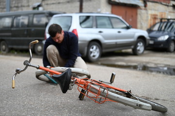 A young man repairing a bicycle on the street
