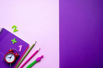 Colored different school supplies on lilac paper background. Back to school concept. Flat lay, top view, copy space