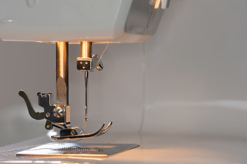 Betriebsbereite Nähmaschine mit Licht im Detail mit eingelegten Fäden und Spule