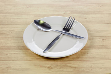 Spoon and fork on white plate