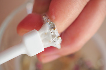 Jeweller hand cleaning and polishing vintage jewelry diamond ring closeup