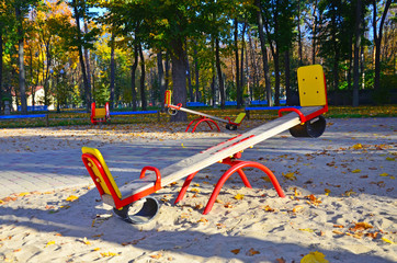 Empty playground with carousels and swings on a warm sunny autumn day