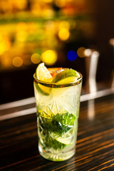 Close-up mojito cocktail on the bar, blurred background.